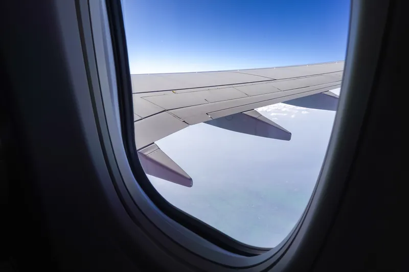Tragfläche eines Flugzeugs durch das Kabinenfenster gesehen
